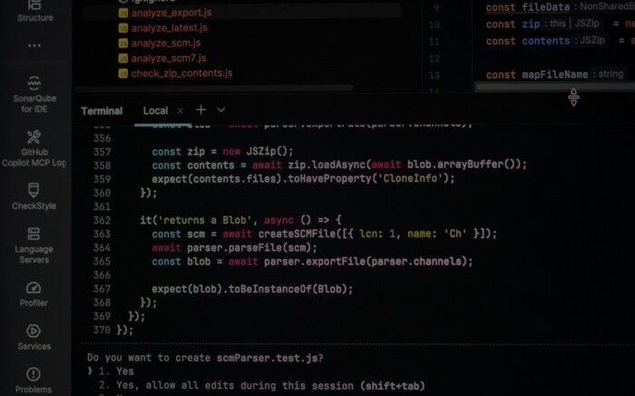A code editor and terminal on a dark screen, dimmed, showing a JavaScript test file.